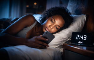 "woman using phone late at night unable to sleep"
